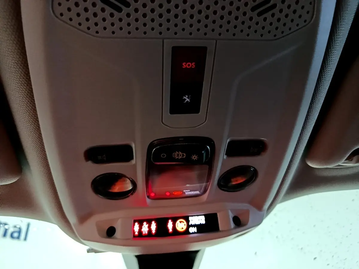 Vue intérieure du plafonnier avec boutons de commande et alerte SOS allumée dans un Peugeot 2008 gris clair.