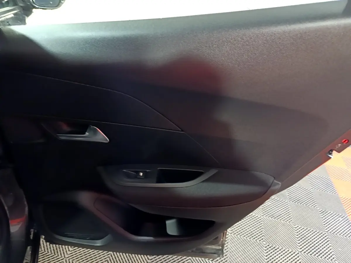 Vue intérieure du panneau de porte arrière gauche noir du Peugeot 2008 gris clair 2021.
