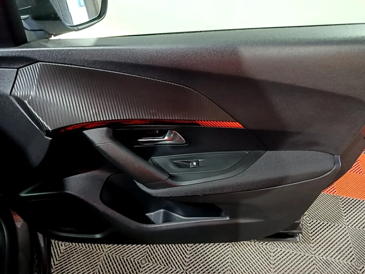 Intérieur côté gauche de porte PEUGEOT 2008 gris clair, avec poignée argentée et insert décoratif noir texturé.