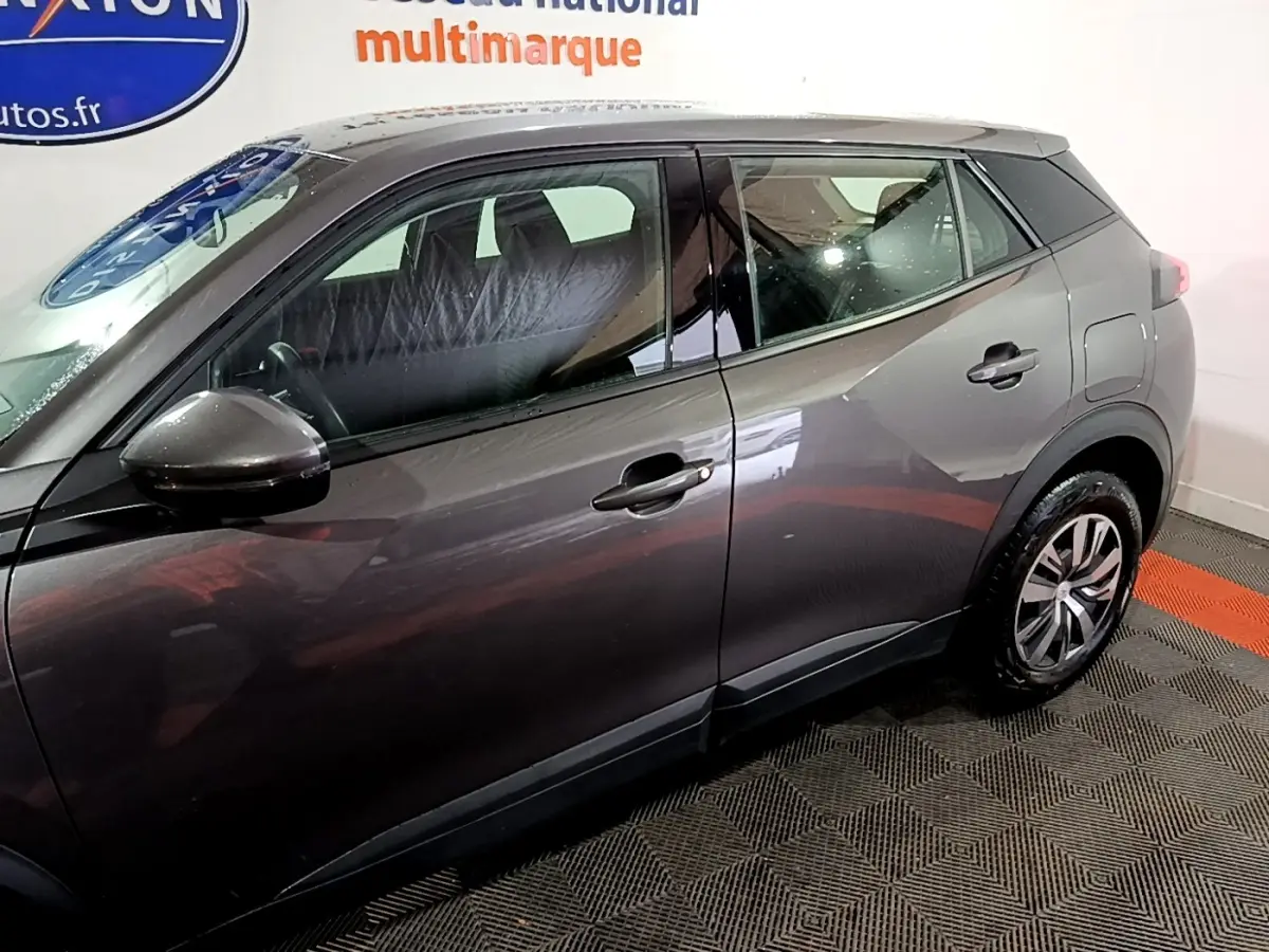 Profil côté gauche du Peugeot 2008 gris clair, mettant en valeur les lignes épurées et les jantes alliage.