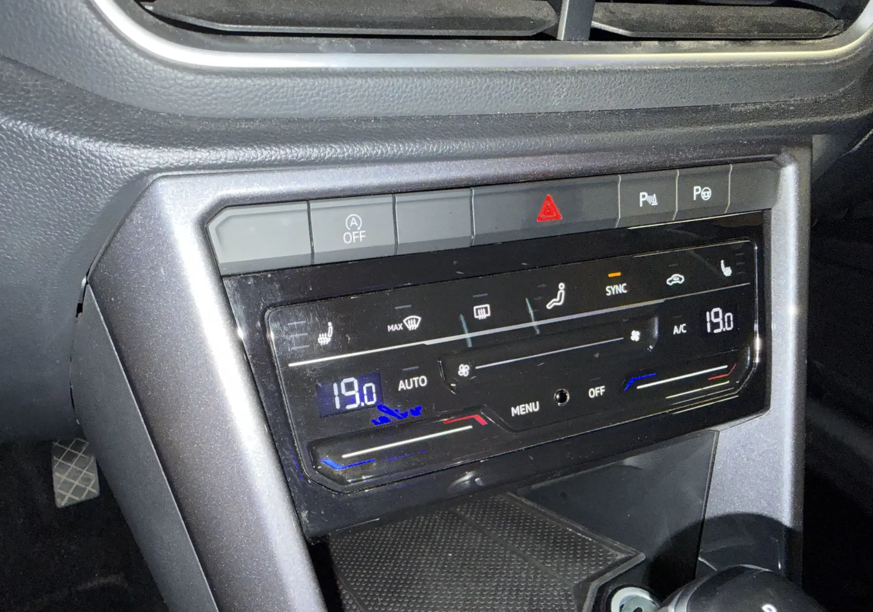 Gros plan sur la console centrale du Volkswagen T-Roc 2022, affichant la climatisation digitale et les commandes de sièges chauffants.