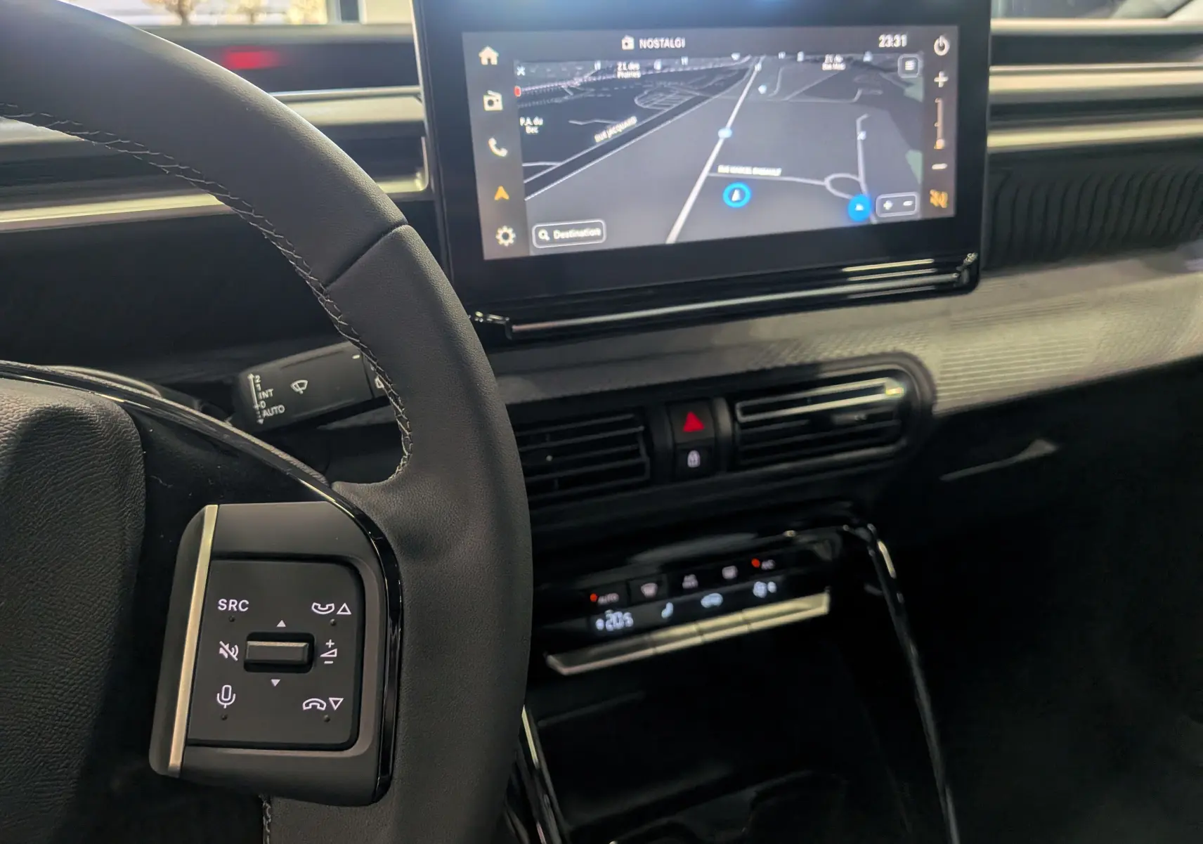 Vue intérieure côté gauche du tableau de bord du Citroën C3 Aircross hybride 2026 avec écran tactile et commandes au volant.