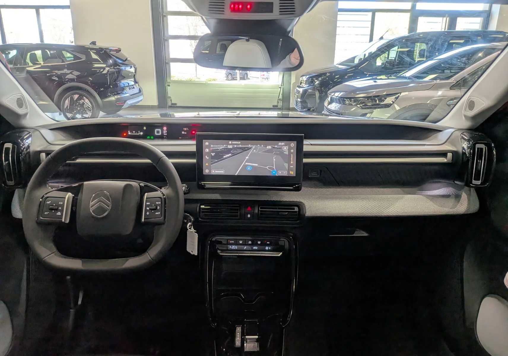 Vue intérieure frontale du tableau de bord du Citroën C3 Aircross hybride gris Mercury avec écran tactile central et volant multifonction.