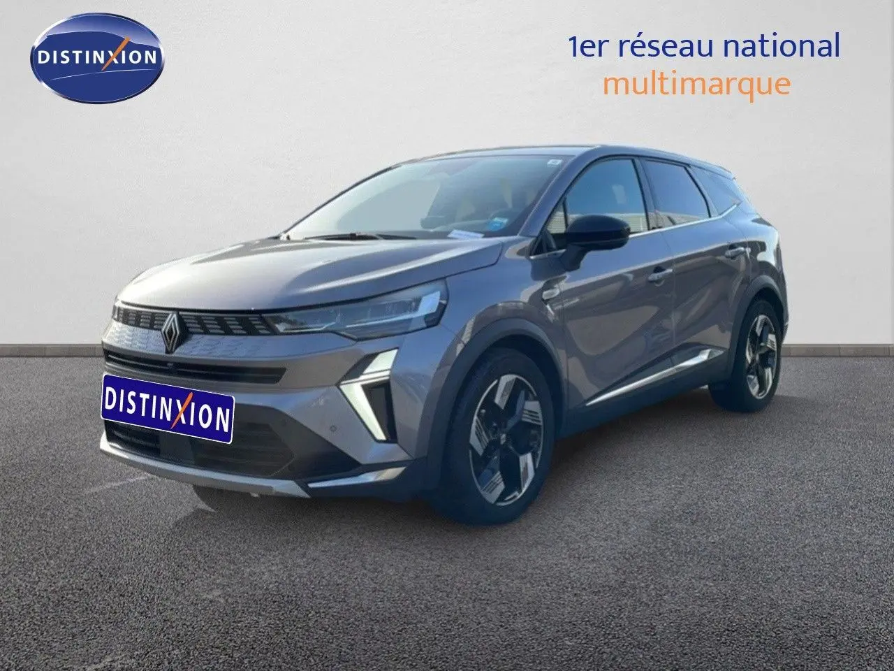 Renault Symbioz 2025 gris cassiopée métal, vue 3/4 avant droit, avec calandre distinctive et jantes bi-ton.