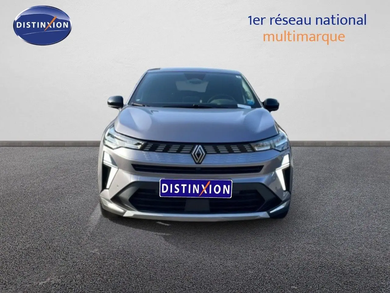 Vue frontale d'une Renault Symbioz gris cassiopée métal 2025 avec calandre lumineuse et logo central distinctif.