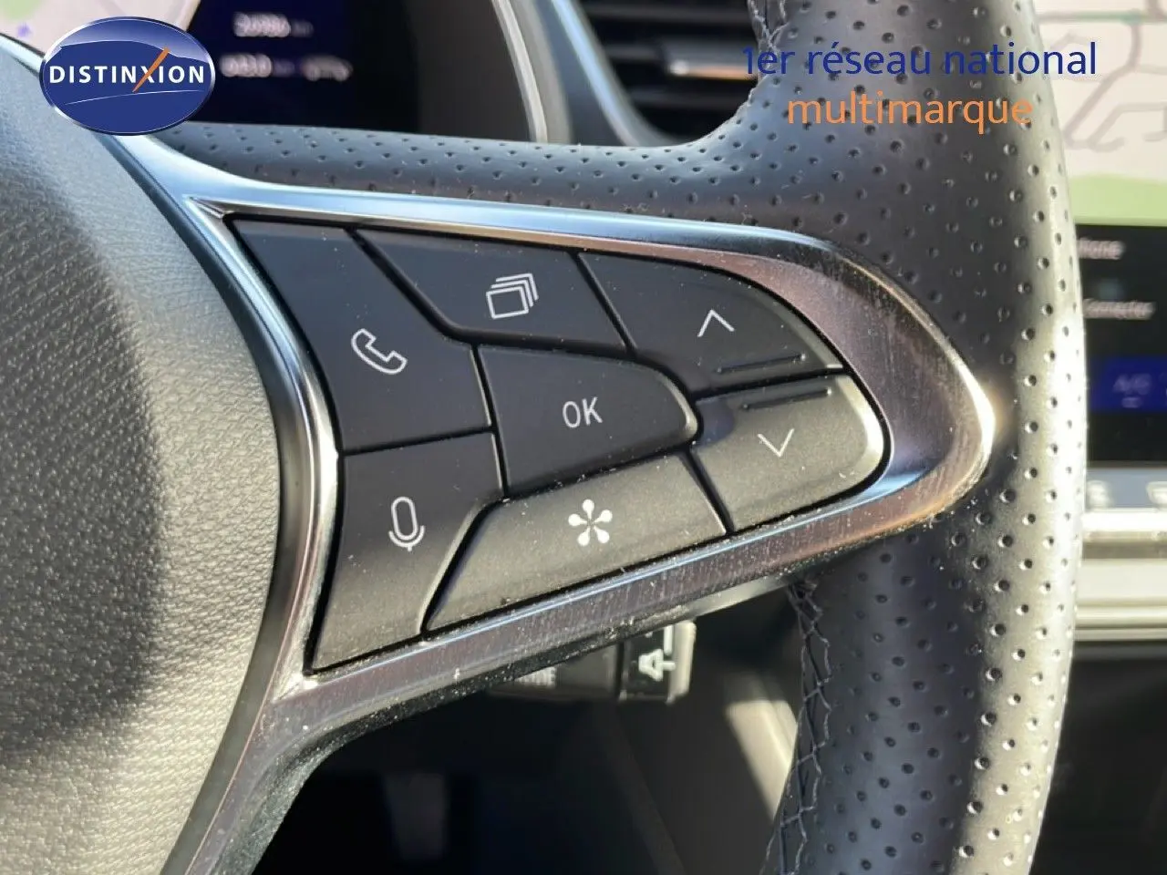 Gros plan sur les commandes au volant en cuir perforé de la Renault Symbioz gris cassiopée métal, version hybride 2025.