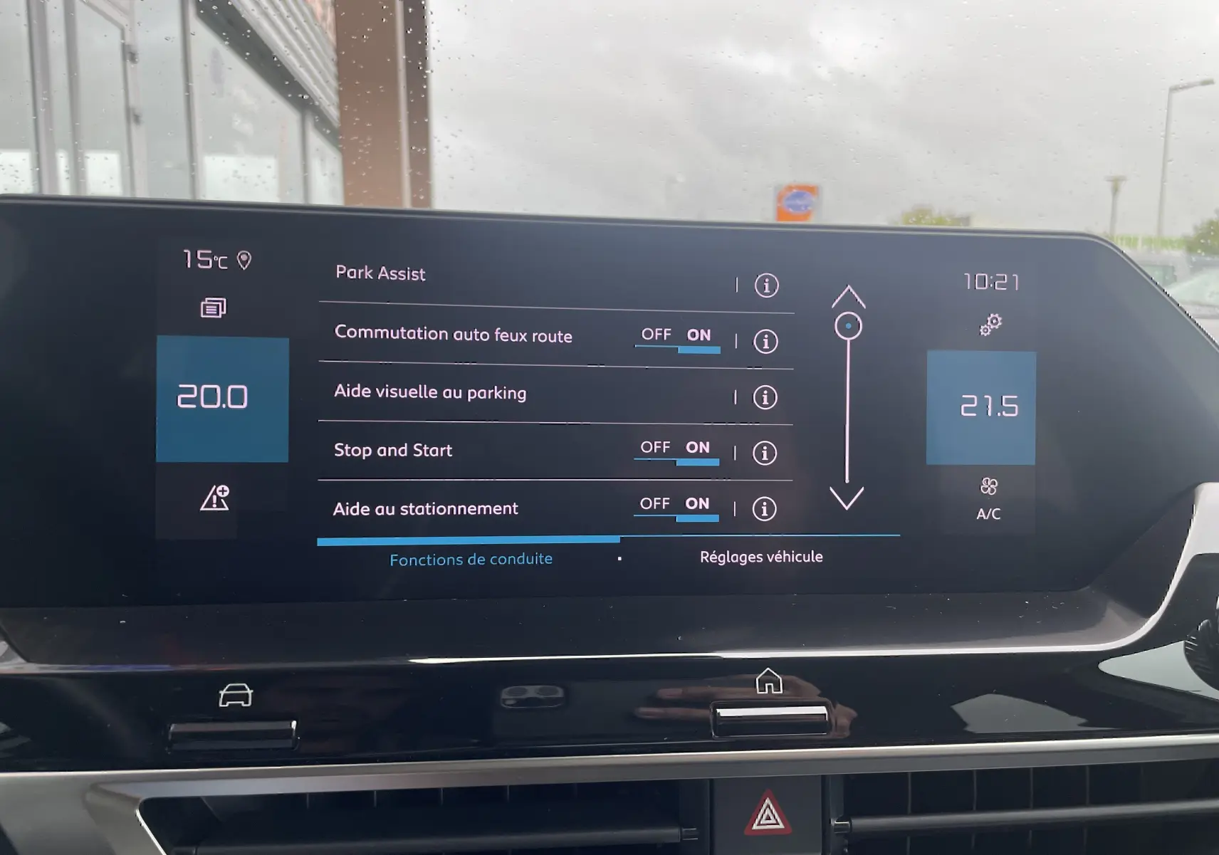 Écran tactile central de la Citroën C4 blanc 2022 affichant les réglages d'aide au stationnement et climatisation.