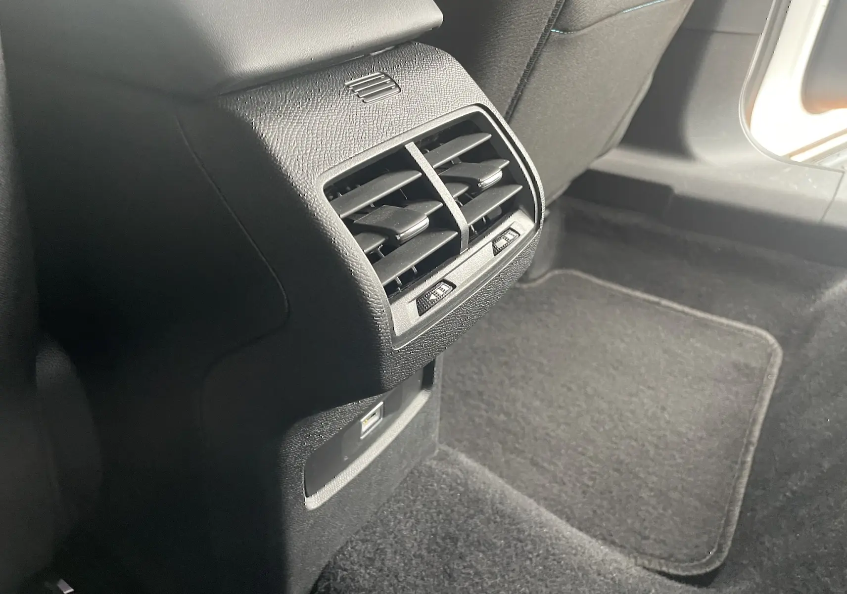 Gros plan sur la sortie d'air arrière et prise USB dans l'habitacle noir du Citroën C4 1.2 PureTech 130 Shine 2022.