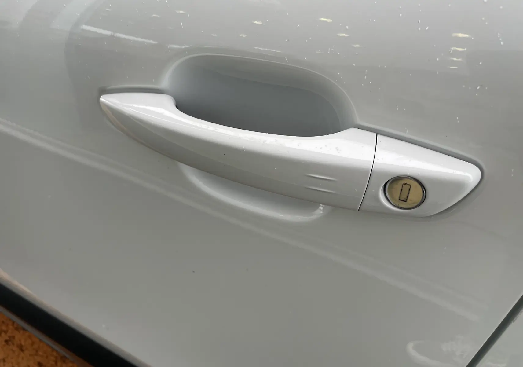 Poignée de porte blanche côté droit de la Citroën C4 1.2 PureTech 130 Shine avec serrure intégrée.