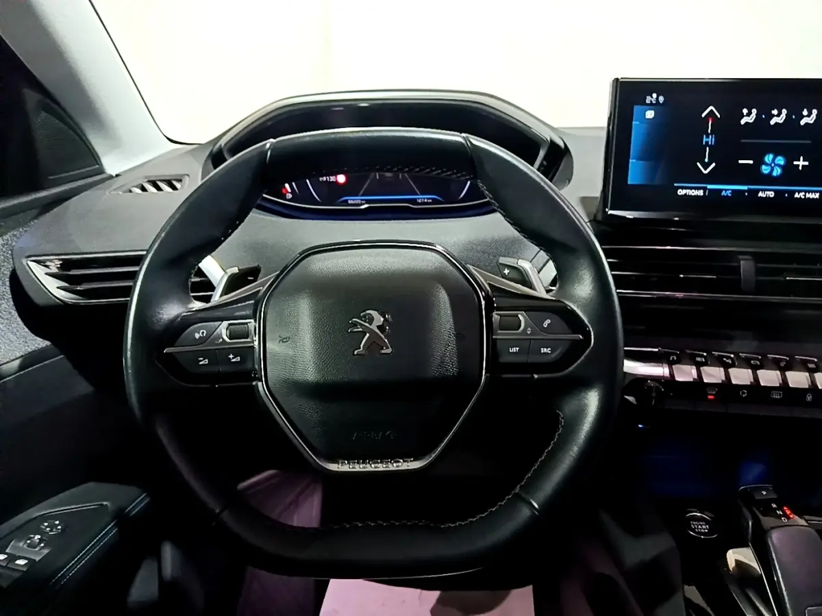 Vue centrée sur le volant cuir noir multifonctions du Peugeot 3008 2022 avec tableau de bord digital et écran tactile.