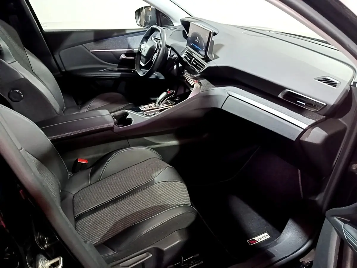 Intérieur avant droit du Peugeot 3008 noir, volant cuir multifonctions et écran tactile central visible.