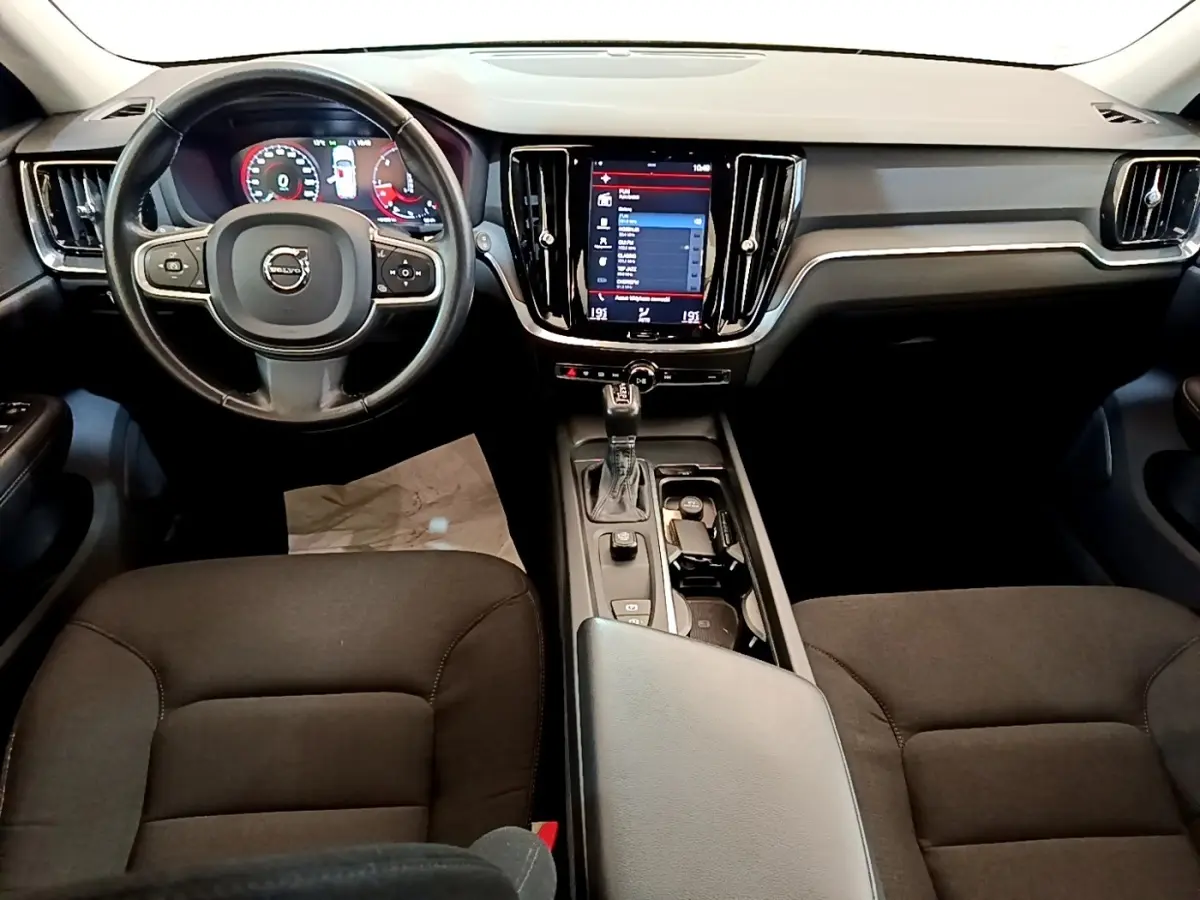 Vue intérieure avant centrée sur le tableau de bord et volant cuir noir de la Volvo V60 D3 Business 2020.