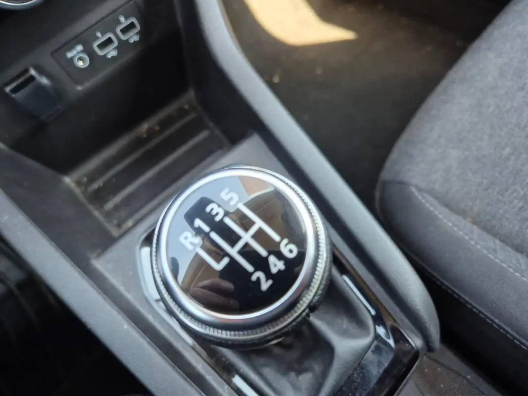 Gros plan sur le levier de vitesses manuel noir de la Renault Clio V TCe 90 Equilibre, intérieur tissu gris visible.