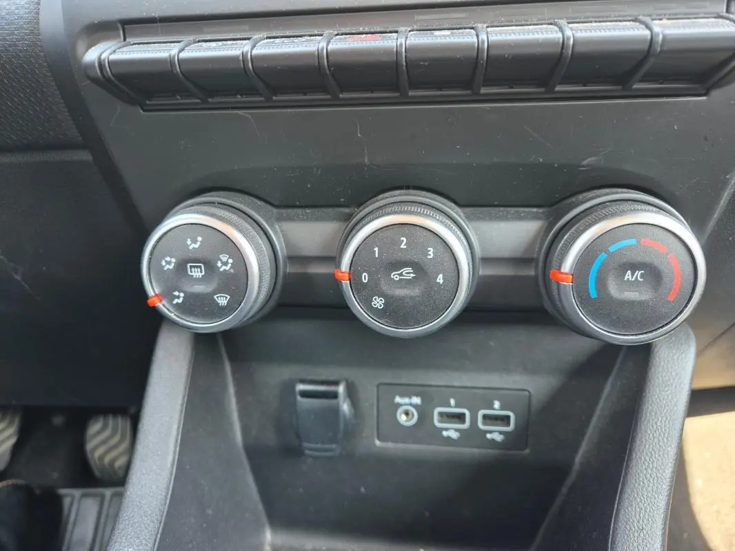 Vue rapprochée des commandes de climatisation manuelle et des ports USB dans une Renault Clio V TCe 90 noire de 2022.