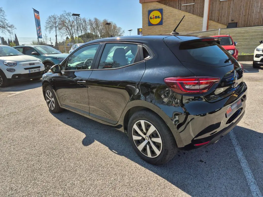 Vue 3/4 arrière droite d'une Renault Clio noire 2022 stationnée en extérieur, avec jantes alliage et vitres teintées.