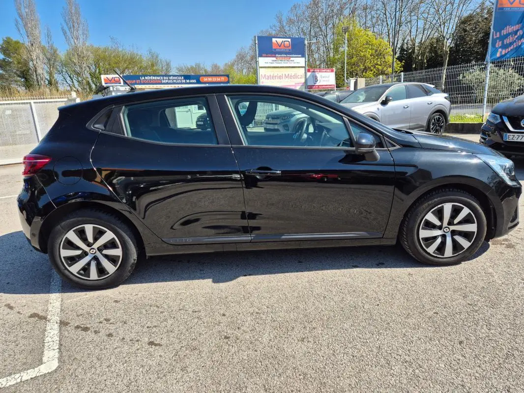 Profil côté gauche d'une Renault Clio V TCe 90 Équilibre noire de 2022, avec jantes alliage et vitres légèrement teintées.