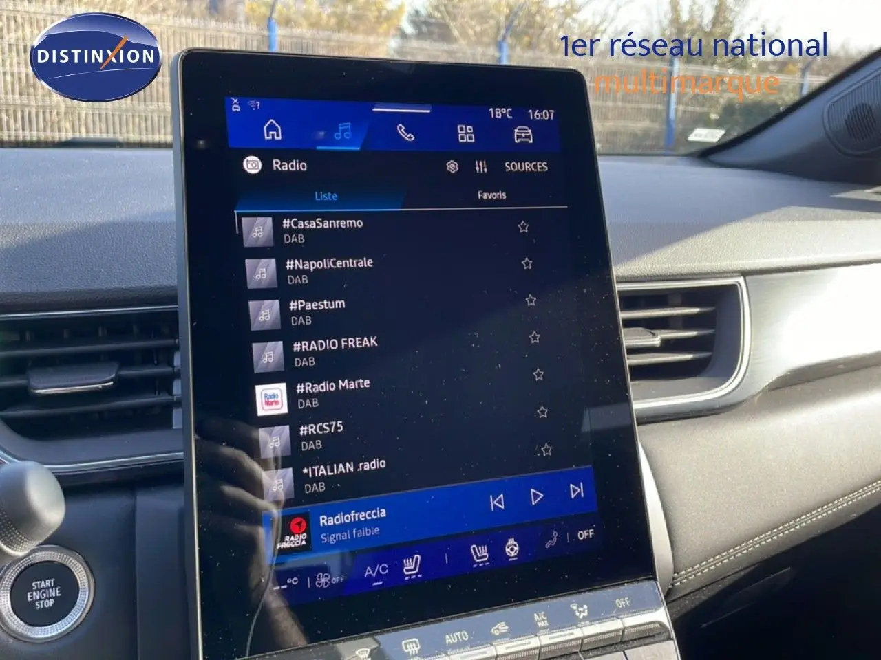 Écran tactile central de la Renault Symbioz gris cassiopée, affichant les stations radio en mode hybride essence.