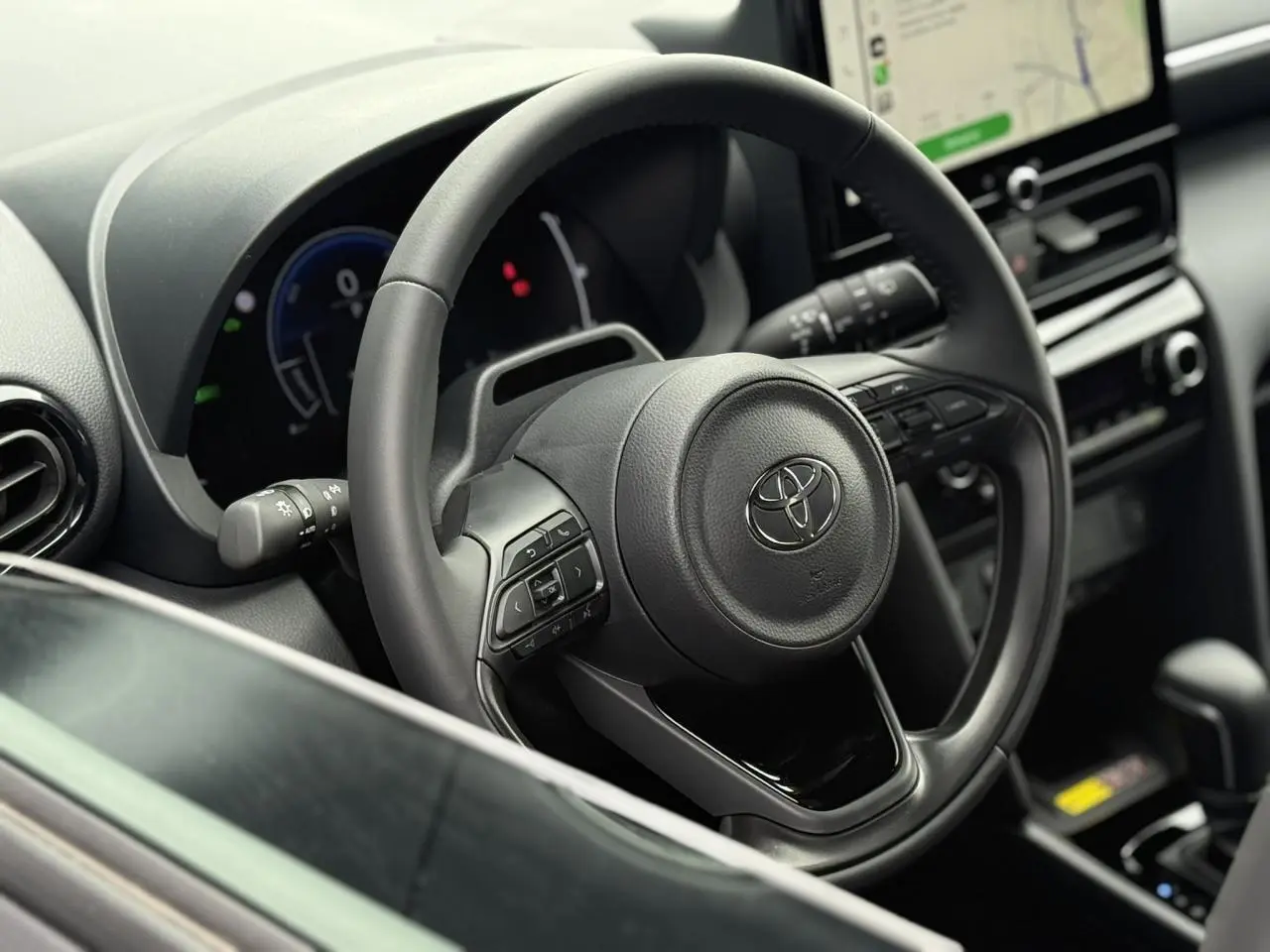 Vue rapprochée du volant cuir et du tableau de bord numérique de la Toyota Yaris Cross 1.5 Hybrid 116 Design.
