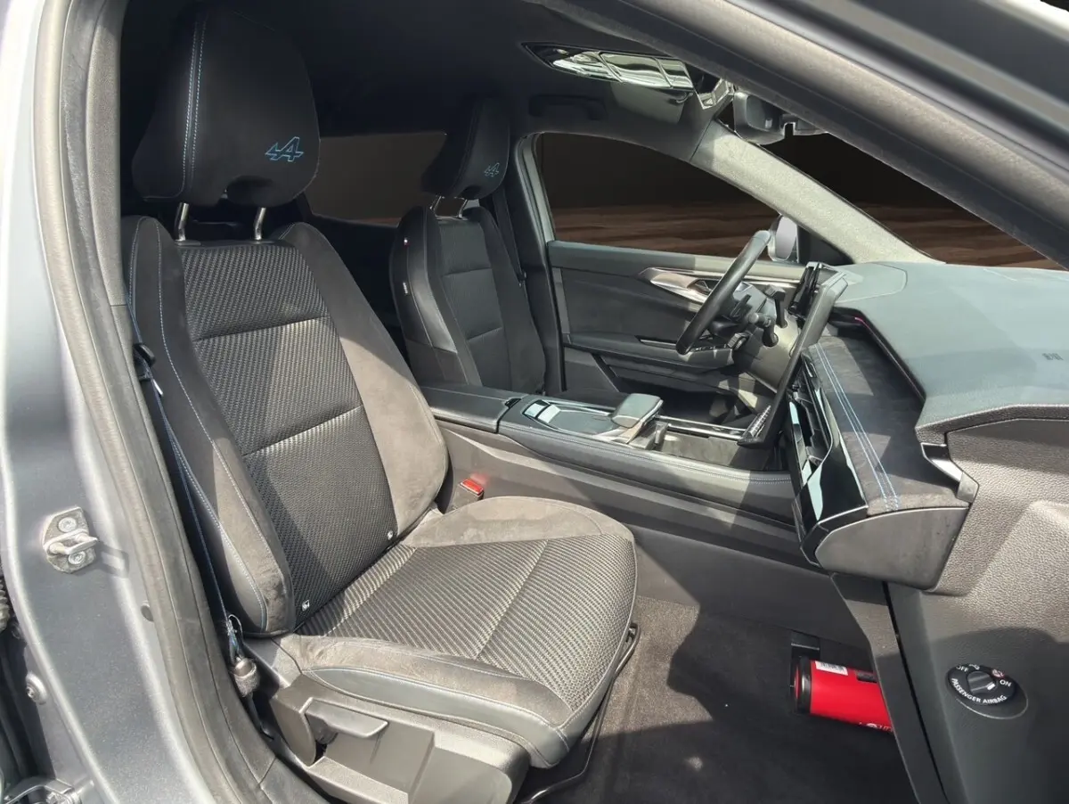 Vue intérieure côté conducteur du Renault Espace gris foncé 2024, sièges noirs avec logo Alpine brodé en bleu.