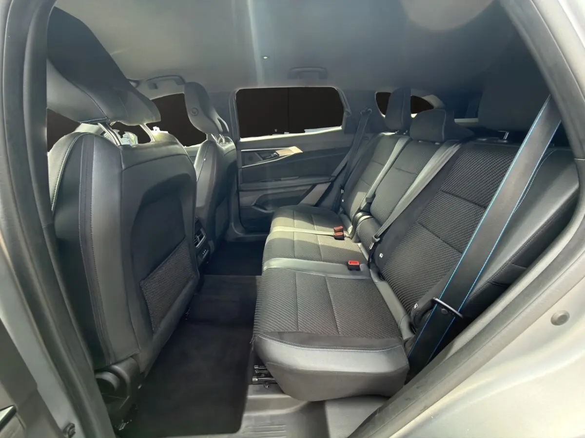 Vue intérieure côté droit des sièges arrière noirs avec surpiqûres bleues du Renault Espace Esprit Alpine E-Tech 2024.