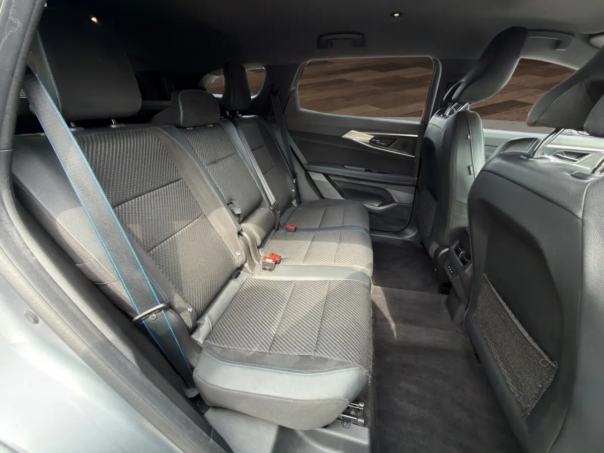 Vue latérale intérieure côté droit des sièges arrière gris foncé avec surpiqûres bleues du Renault Espace 2024 esprit Alpine E-Tech.