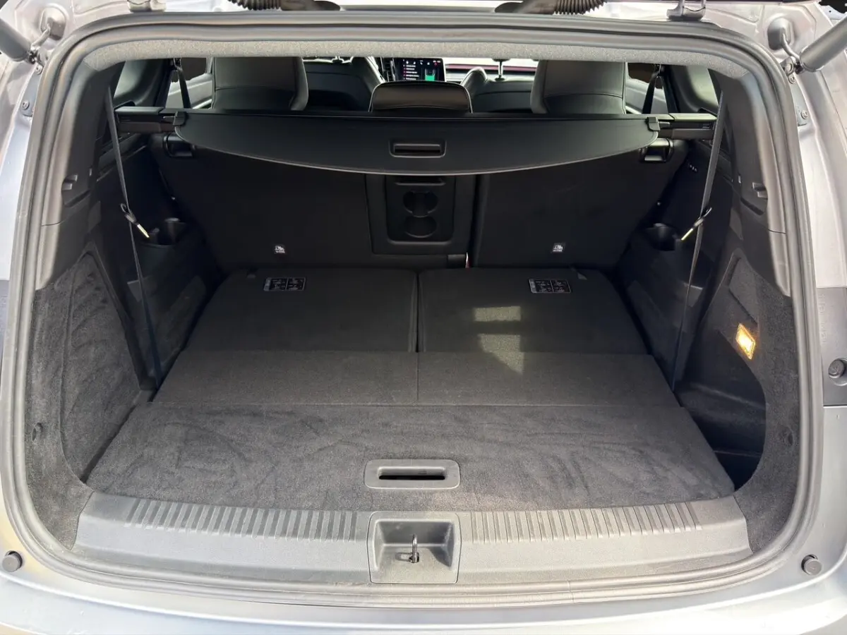 Coffre ouvert d’un Renault Espace gris foncé, vue arrière montrant les sièges arrière rabattus et la tablette cache-bagages.