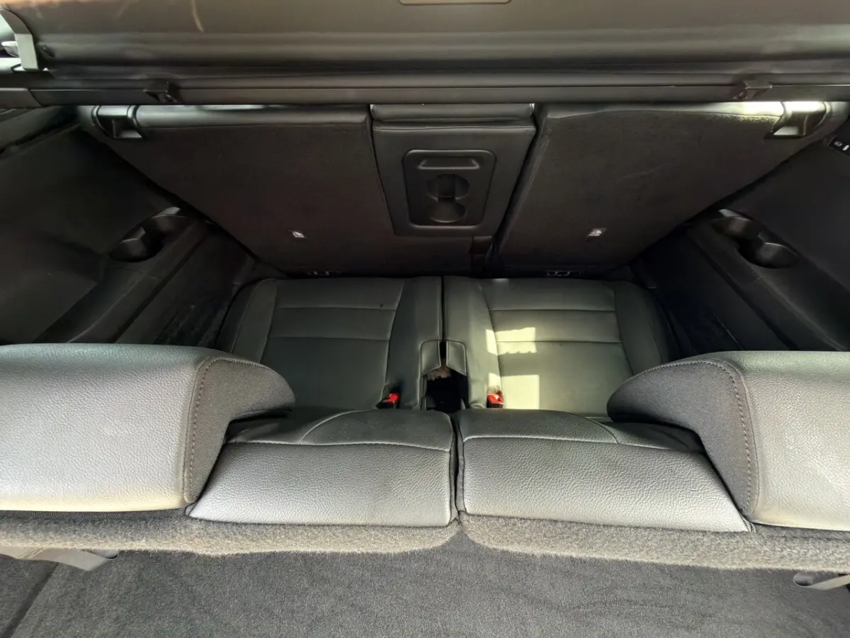 Vue plongeante sur la troisième rangée de sièges noirs rabattus du coffre du Renault Espace gris foncé 2024 esprit Alpine.