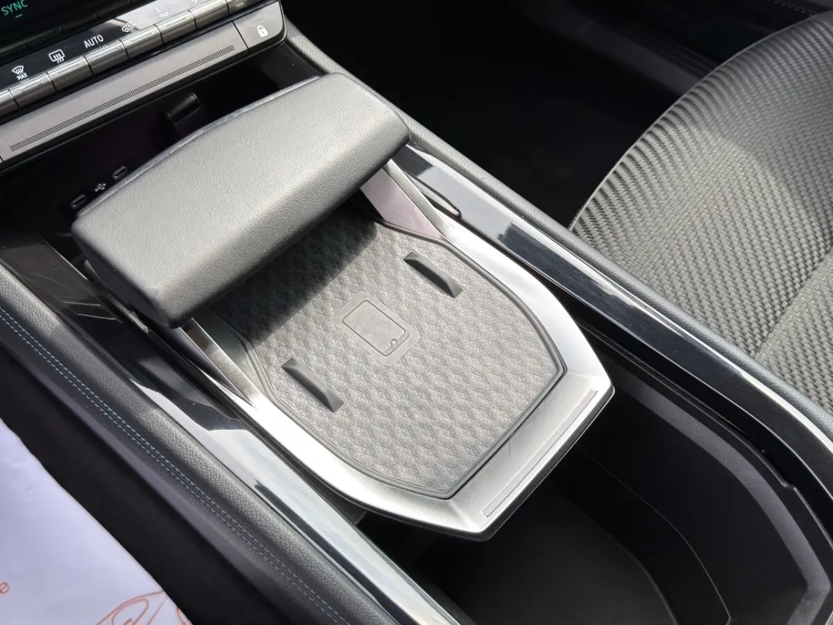 Vue rapprochée de la console centrale grise du Renault Espace 2024 esprit Alpine E-Tech avec zone de recharge sans fil.