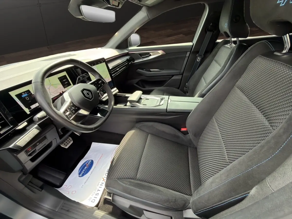 Intérieur avant droit du Renault Espace Esprit Alpine 2024, sièges noirs avec surpiqûres bleues et tableau de bord digital.