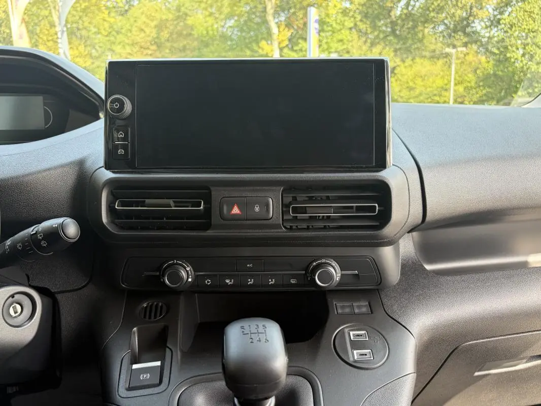 Vue rapprochée de la console centrale intérieure du Peugeot Partner blanc, avec écran tactile et levier de vitesses manuel.