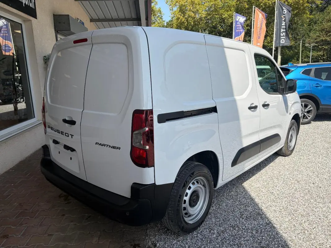 Vue 3/4 arrière droite d'un Peugeot Partner blanc utilitaire avec portes arrière battantes et protections noires.