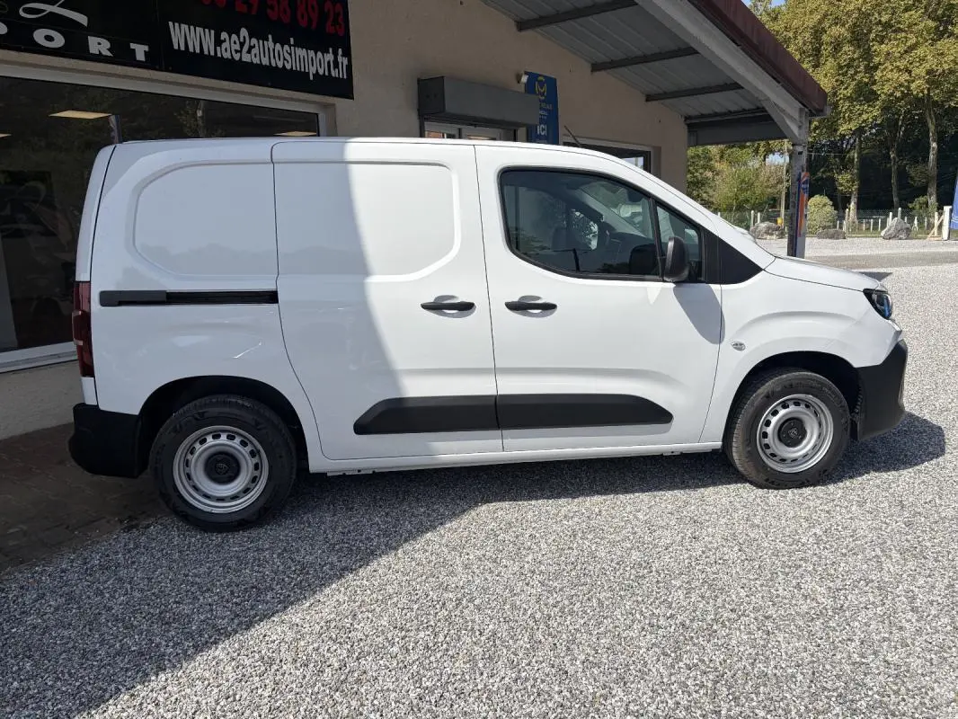 Peugeot Partner blanc vu de profil côté droit, fourgon utilitaire avec protections noires et jantes acier.