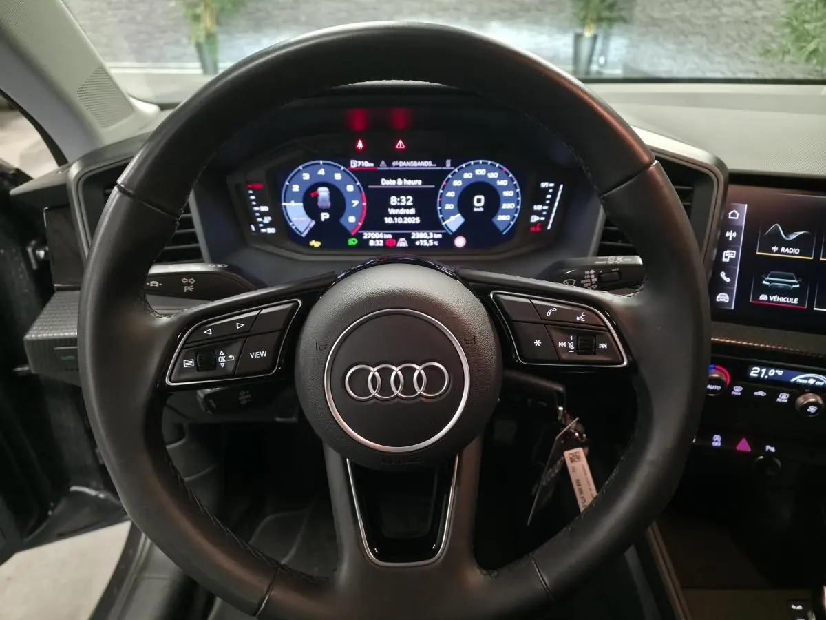 Vue frontale du volant cuir noir multifonctions et du tableau de bord digital de l'Audi A1 Sportback gris 2024.