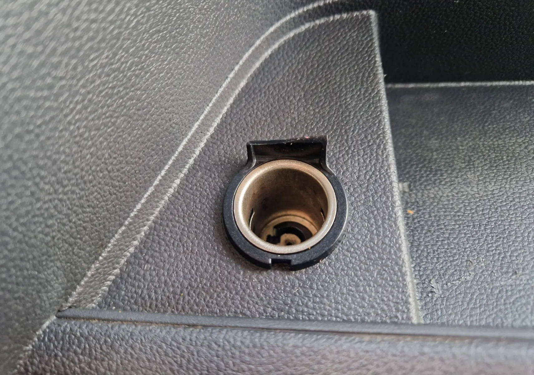 Prise allume-cigare en gros plan sur la console intérieure noire du Renault Master blanc L2H2 2020.