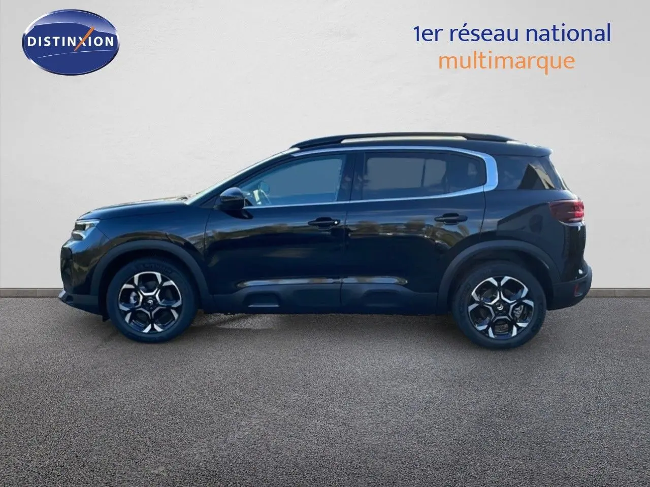 Profil latéral droit d'un Citroën C5 Aircross noir perla metal, SUV compact avec jantes alliage et barres de toit chromées.