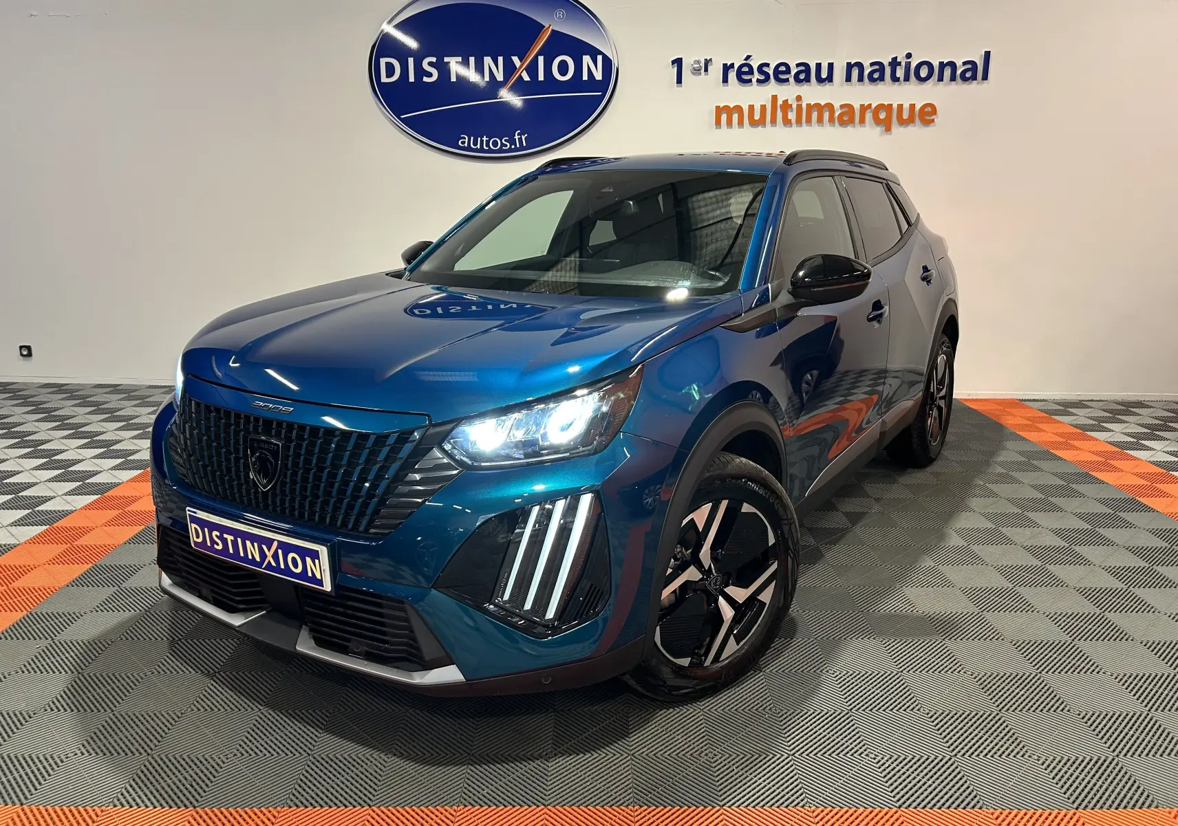 Peugeot 2008 Allure Hybrid 145 bleu Obsession en 3/4 avant droit, phares allumés et jantes noires distinctives.