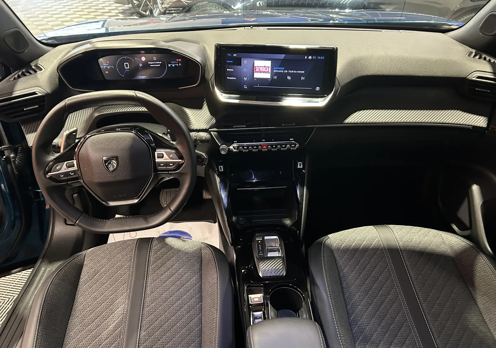 Vue intérieure avant du Peugeot 2008 Allure Hybrid 145, tableau de bord moderne avec écran tactile et volant compact noir.