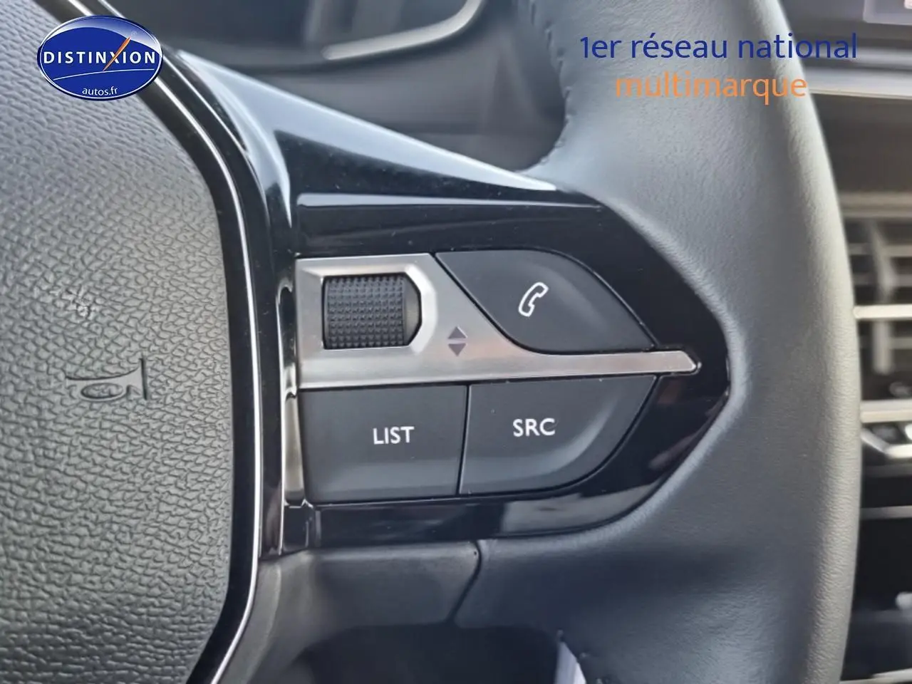 Gros plan sur les commandes audio au volant à gauche d’une Peugeot 208 1.2 PureTech 100 Allure 2024.