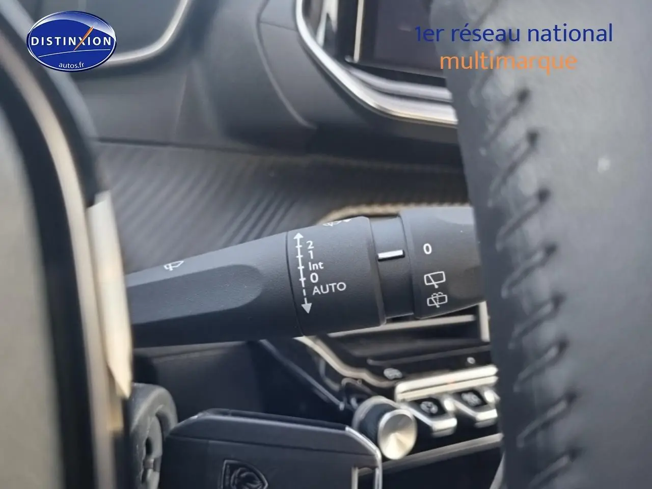 Gros plan sur la commande d’essuie-glace côté gauche du tableau de bord d’une Peugeot 208 gris sélénite 2024.
