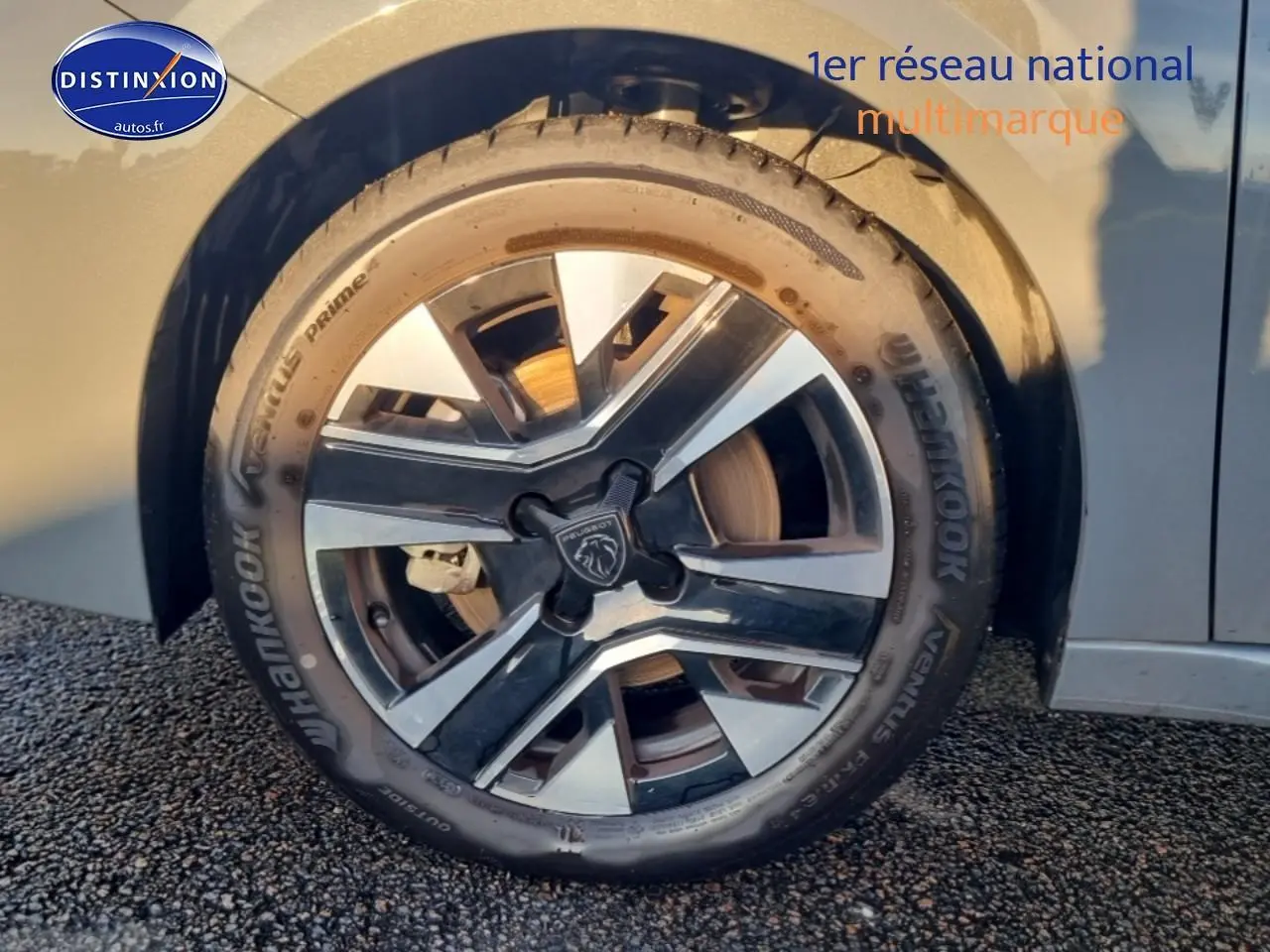 Gros plan sur la jante alu bicolore et pneu Hankook d'une Peugeot 208 gris sélénite côté avant droit.