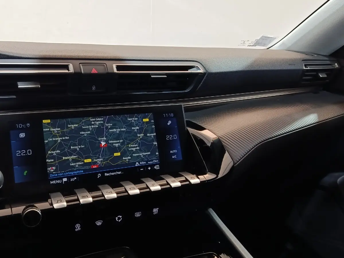 Vue intérieure du tableau de bord de la Peugeot 508 gris clair, avec écran tactile de navigation et commandes piano.