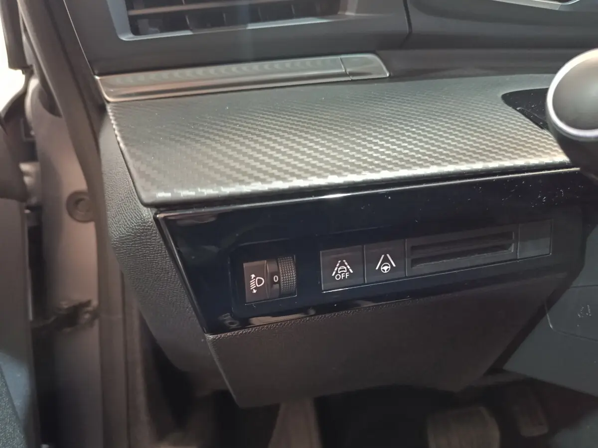 Détail du tableau de bord côté gauche avec commandes d'assistance à la conduite sur Peugeot 508 gris clair 2020.