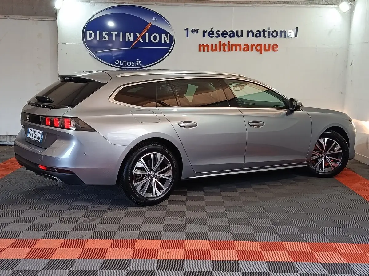 Peugeot 508 BlueHDi gris clair vue de profil droit en break, avec jantes alliage et feux arrière LED distinctifs.