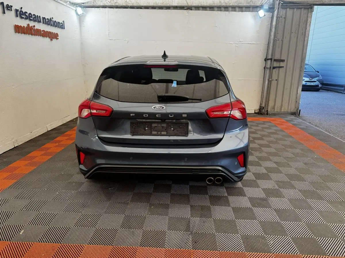 Vue arrière d'une Ford Focus bleu foncé 5 portes avec double sortie d'échappement et feux arrière LED.