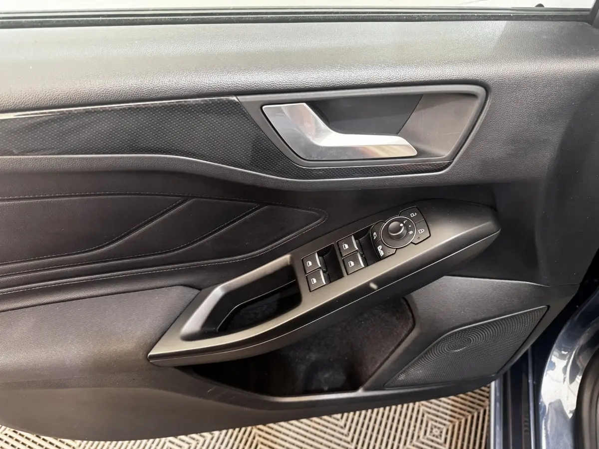 Intérieur porte avant gauche de Ford Focus bleu 2022, avec commandes vitres et rétroviseurs noirs.