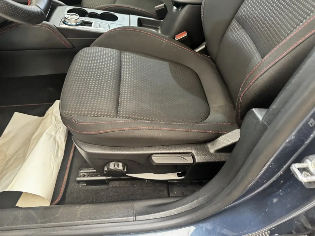 Vue rapprochée du siège avant gauche noir avec surpiqûres rouges de la Ford Focus St-Line bleu 2022.