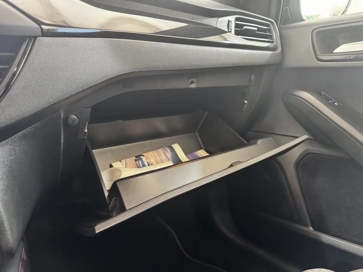 Intérieur de la Ford Focus 5P 2022, vue sur la boîte à gants ouverte côté passager avec tableau de bord noir.