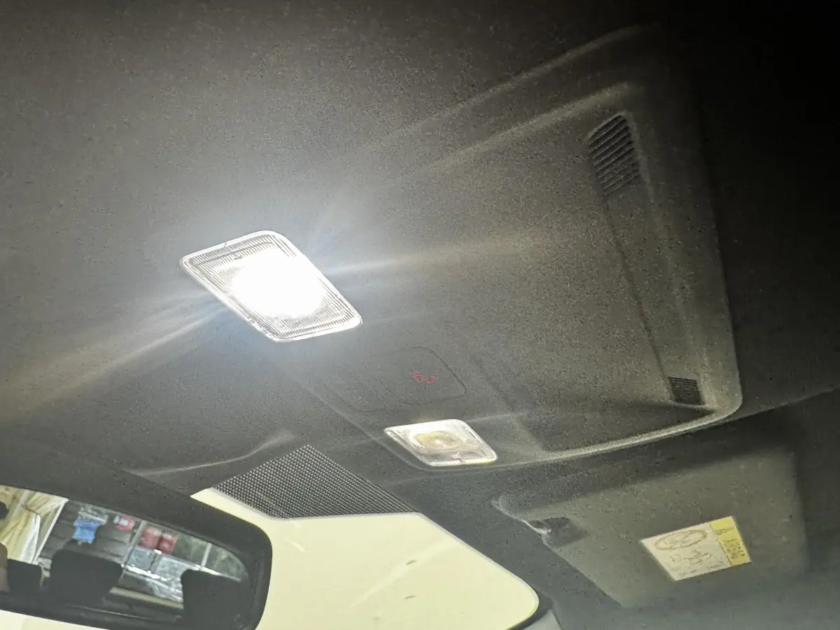 Plafonnier intérieur allumé vu de l'arrière vers l'avant dans une Ford Focus 5 portes bleu 2022.