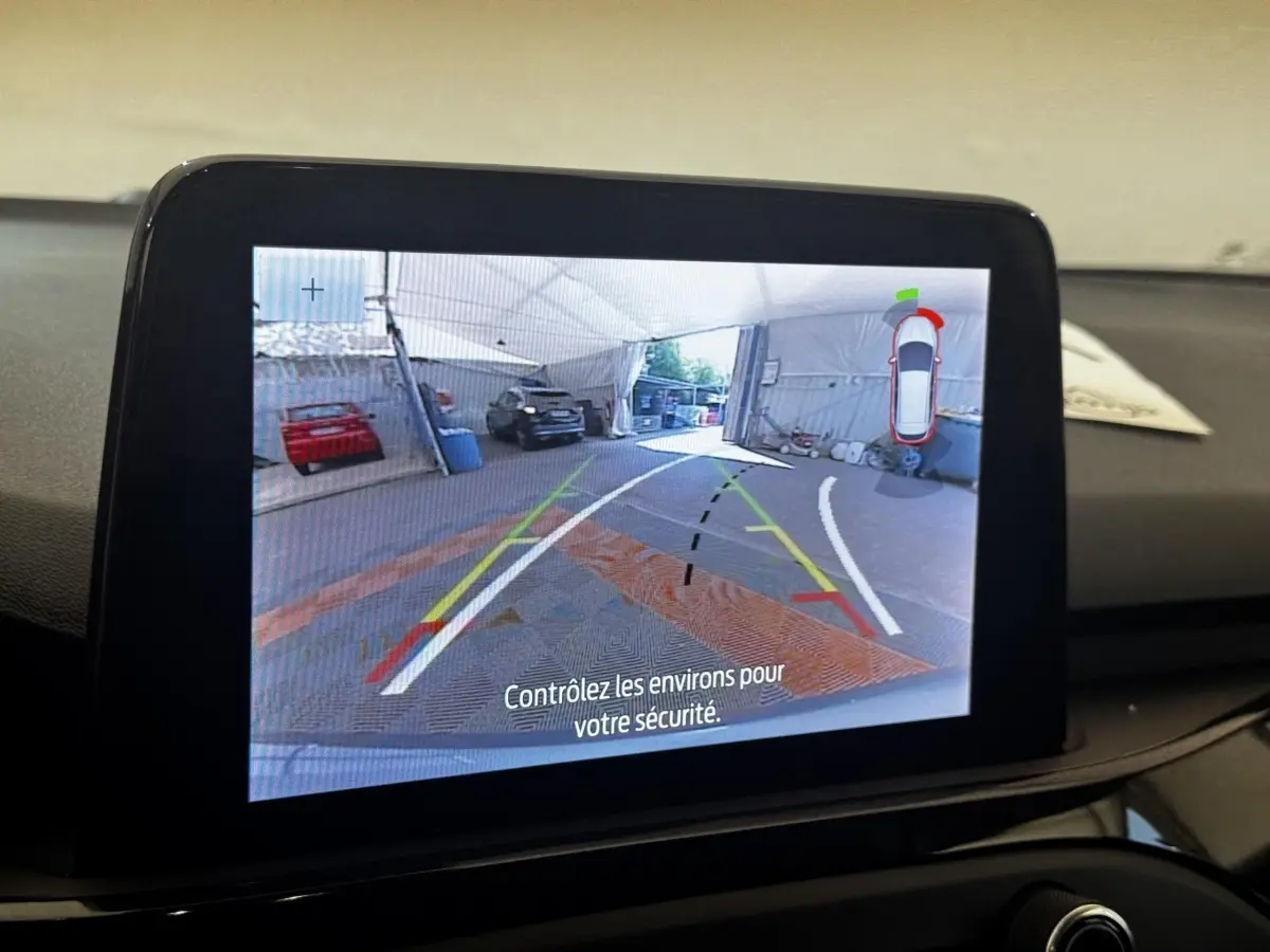 Écran tactile intérieur montrant la caméra de recul avec guidage dynamique d'une Ford Focus bleu 2022.