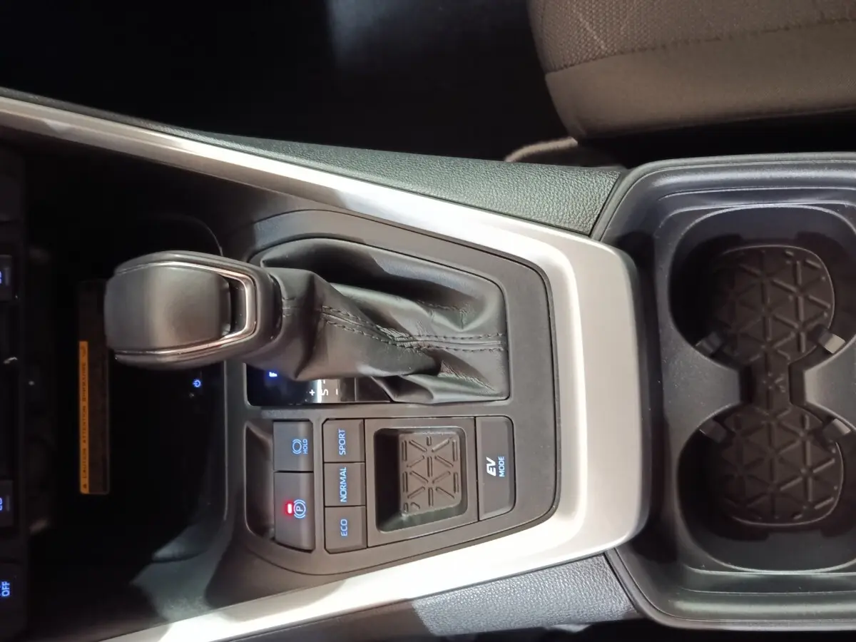 Vue rapprochée de la console centrale du Toyota RAV4 Hybride 2WD 218ch 2021 avec levier de vitesse et commandes de mode de conduite.